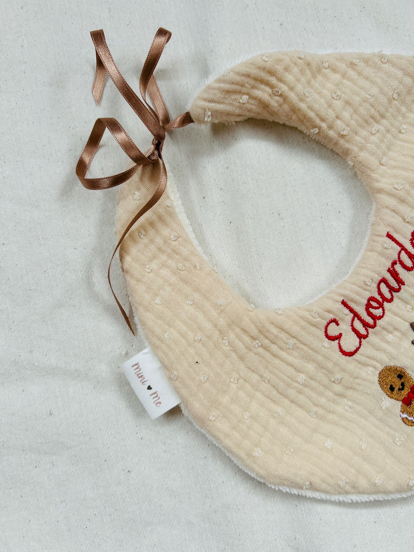 dettaglio bavetta cucita a mano con chiusura a laccetto in raso