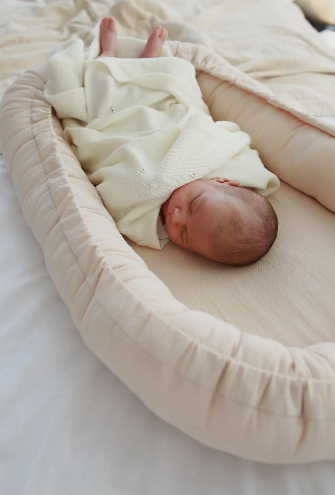Neonato che dorme con copertina in lana Merino bianca