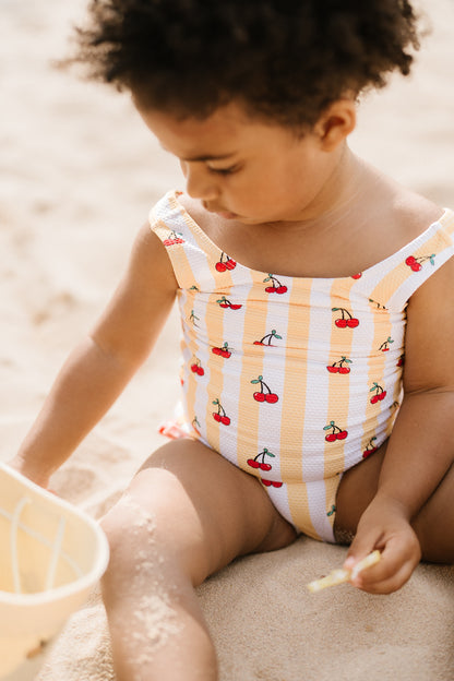 Capri soleil | Costume da bagno intero bimba a righe bianche/gialle con ciliege