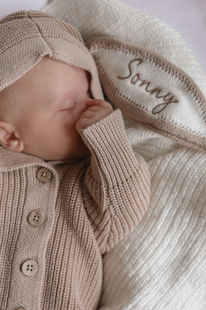 Dettaglio del nome ricamato sul cappuccio della tutina con orecchie da coniglietto